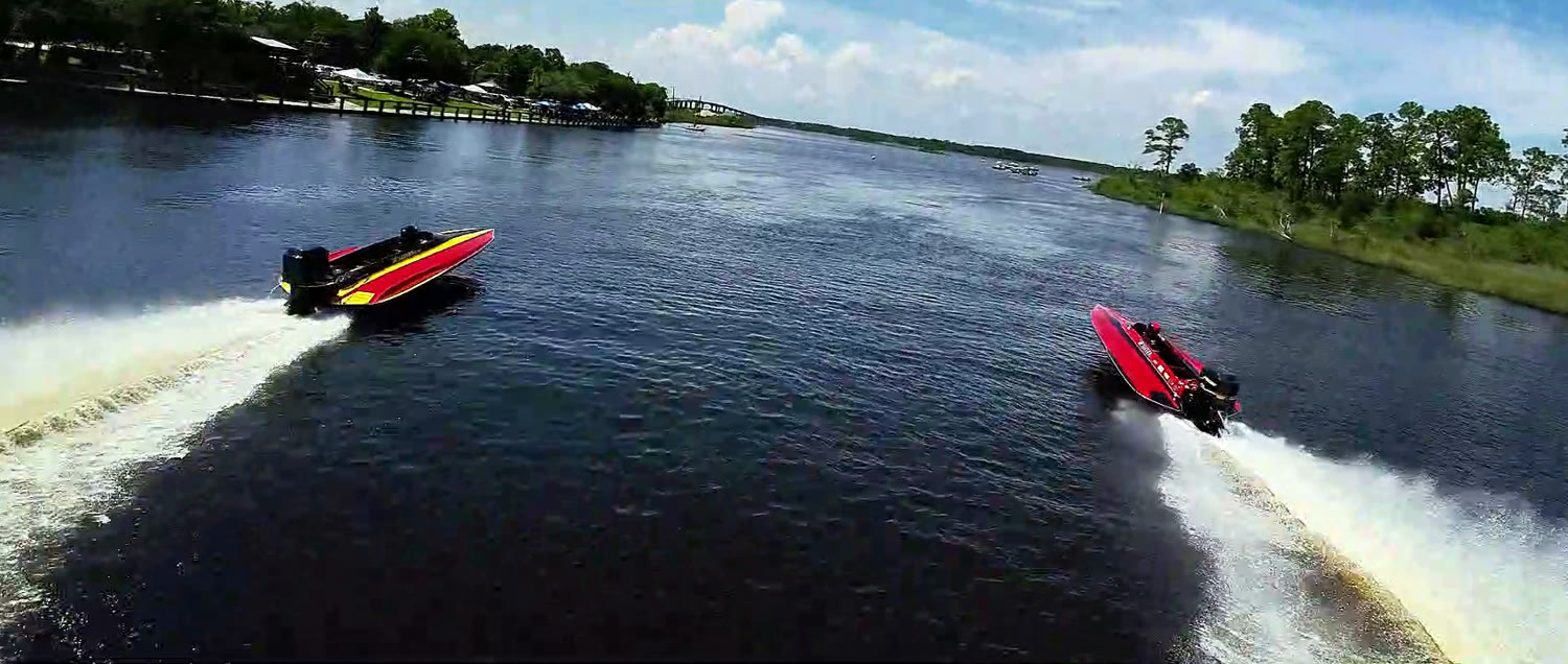 Two drag boats racing down the Escatawpa River throwing white spray at Smokin' the River City in Moss Point