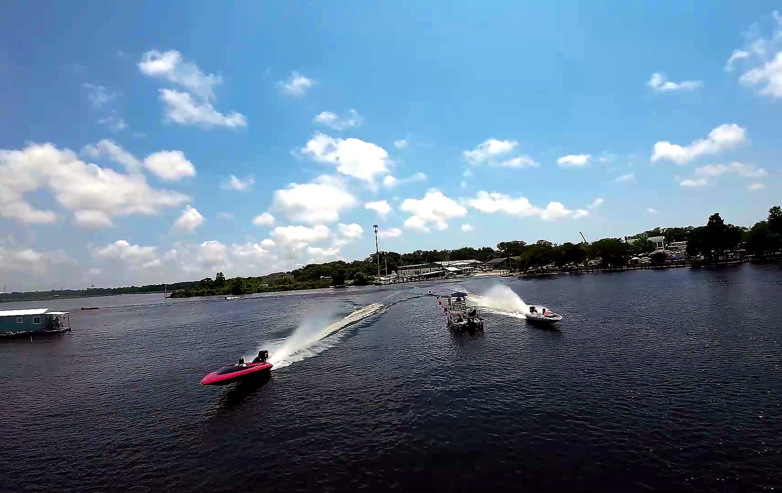 Drag boats racing past spectators lining the bank