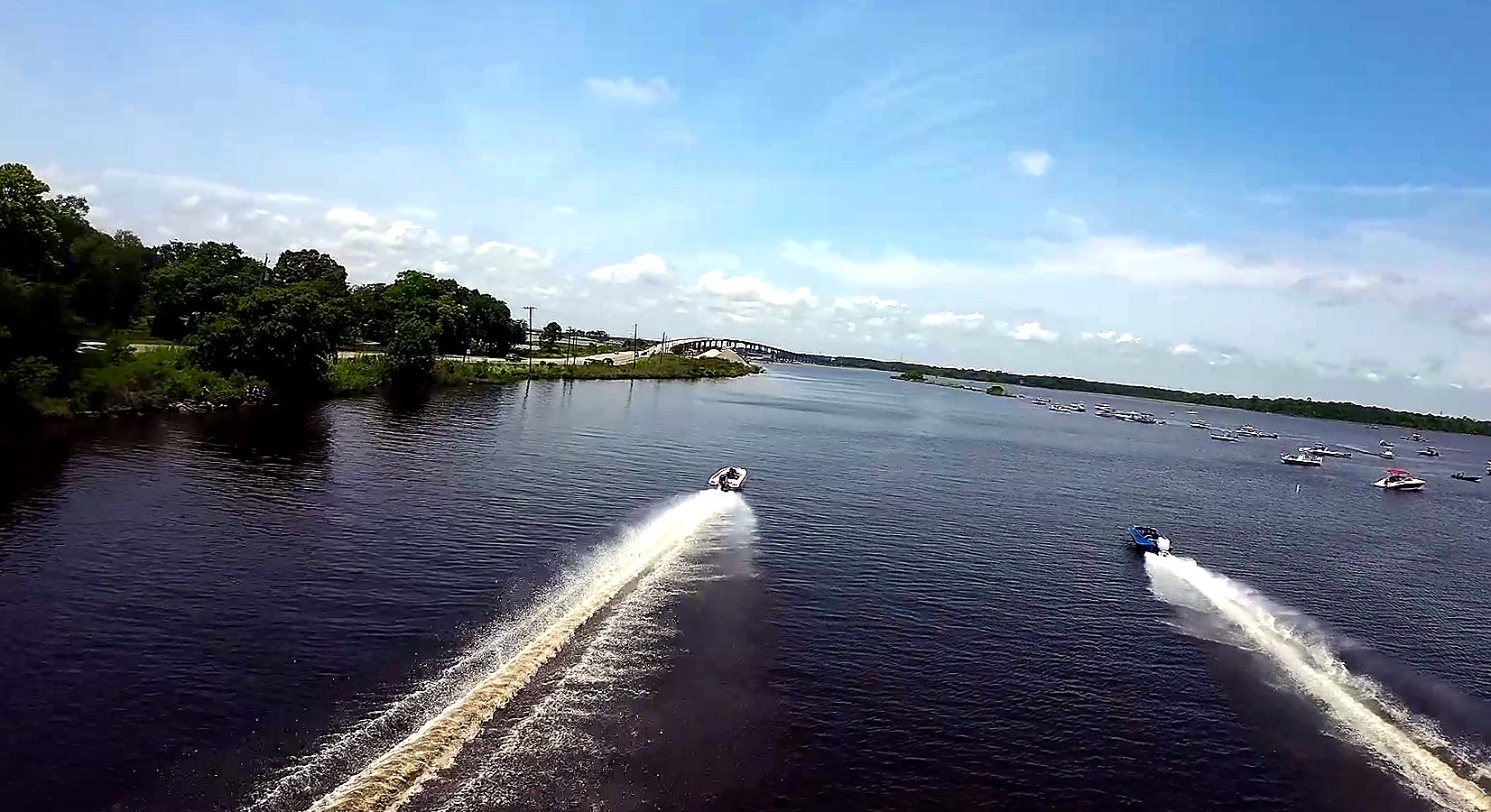Two drag boats racing side by side down the Escatawpa River at Moss Point, throwing long white rooster tails