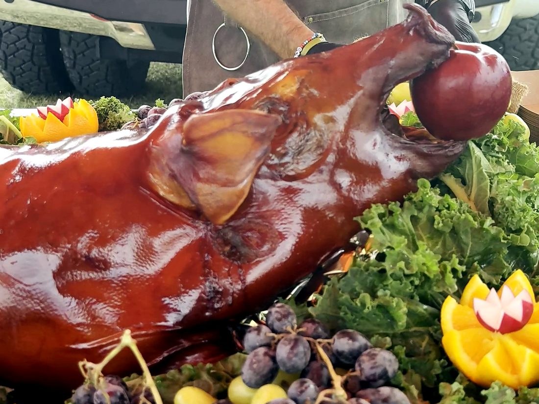 A competition team presents a whole smoked hog at Smokin' the Sip